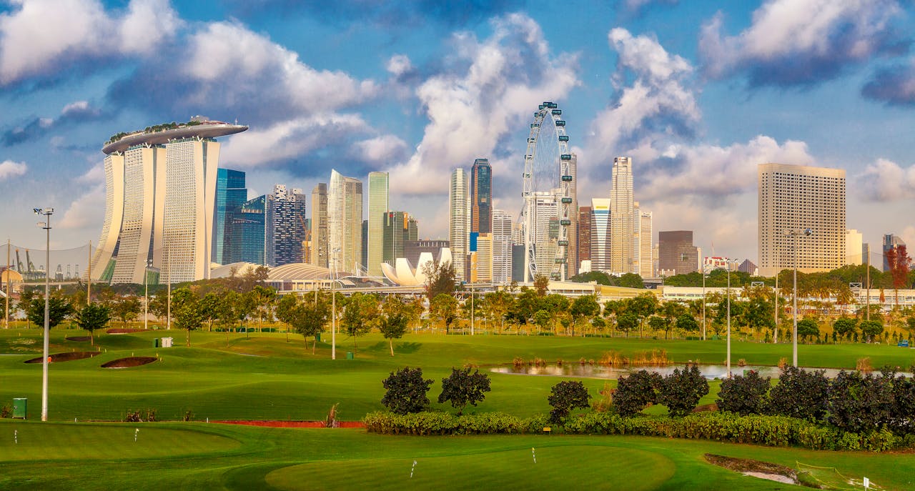Stunning view of Singapore's skyline including Marina Bay Sands and a lush golf course in the foreground.